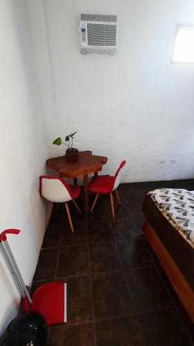 a room with a table and chairs and a bed at Alma de cedrela in Puerto Ayora