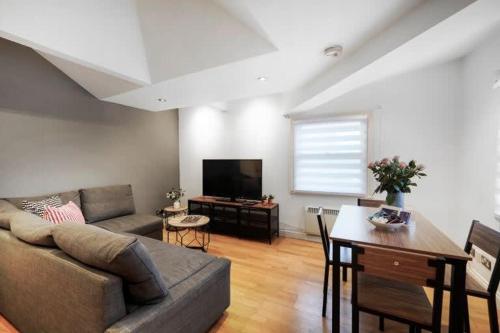 a living room with a couch and a table at New Soho Loft - Apt 3 by Indigo Flats in London