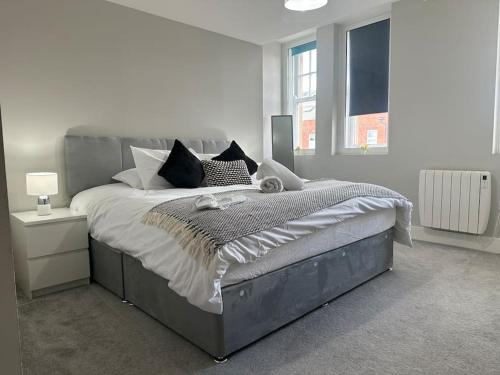 a bedroom with a large bed in a white room at Spacious, bright 2 bed flat with 1 S/king bed. in Brentwood