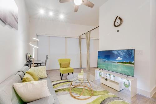 a living room with a couch and a tv at Snazzy loft style 2BR I Gym I Parking I Workspace in Dallas