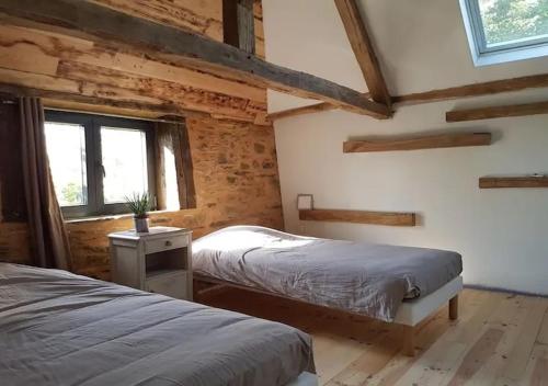 a bedroom with two beds and a window at La Grange in Sarlande