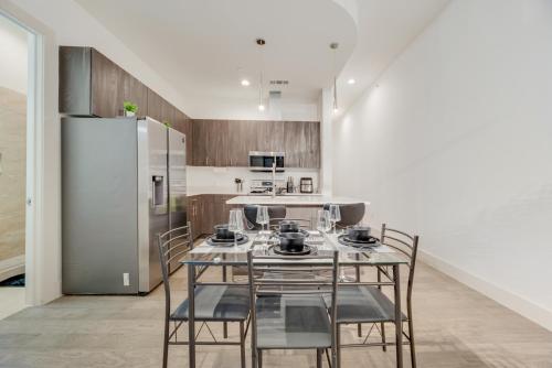 a kitchen with a table with chairs and a refrigerator at Snazzy loft style 2BR I Gym I Parking I Workspace in Dallas