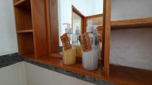 a shelf with soap bottles on it in a bathroom at Alma de cedrela in Puerto Ayora