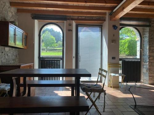 una sala da pranzo con tavolo e 2 finestre di Casa in pietra in collina a Metti