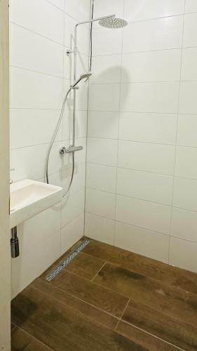 ein Bad mit einer Dusche und einem Waschbecken in der Unterkunft Vakantiehuis De Zwaan in Benk en Donk
