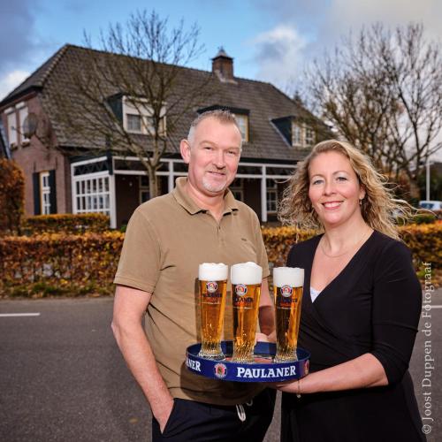 een man en een vrouw met een dienblad bier bij Vakantiehuis De Zwaan in Benk en Donk