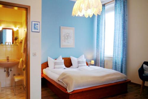 Un dormitorio con una cama grande y una lámpara de araña. en Hotel Grader, en Neustadt an der Waldnaab