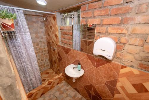 baño con lavabo y pared de ladrillo en Cabaña Kinti Yuraq en Kinti Wasi, en Cajamarca