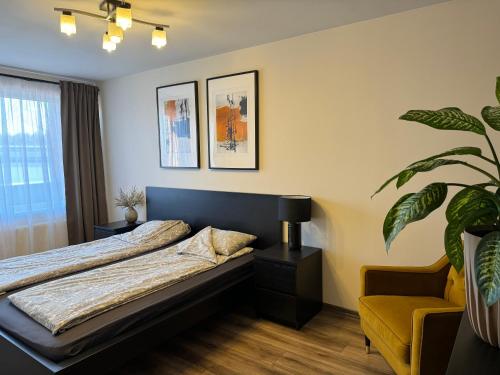 1 dormitorio con 1 cama y 1 silla amarilla en City chic rental en Valmiera