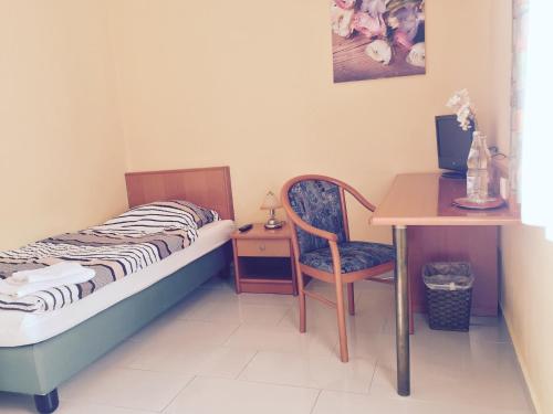 a bedroom with a bed and a desk and a chair at Landhaus Havelse in Garbsen