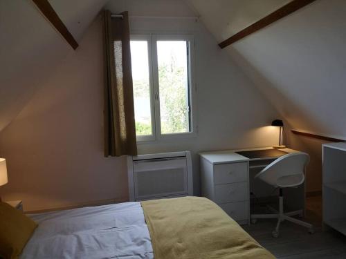 Schlafzimmer mit einem Bett, einem Schreibtisch und einem Fenster in der Unterkunft Gîte des Pins-Chambord-Beauval in Cheverny