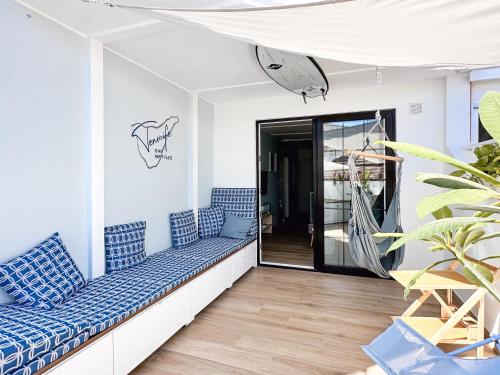 a balcony with blue cushions and a hammock at WOW APARTMENT with jacuzzi and terrace in Los Cristianos