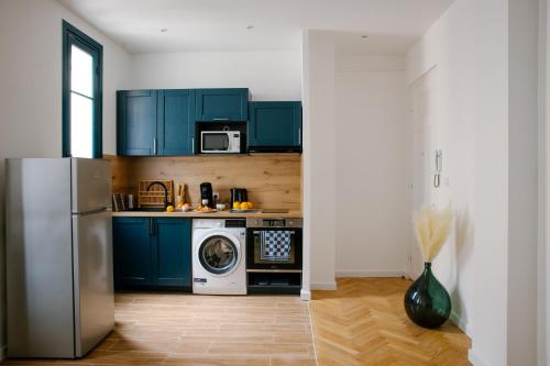 - une cuisine avec des placards bleus et un lave-linge/sèche-linge dans l'établissement Serenity chic apartment Nice center, à Nice