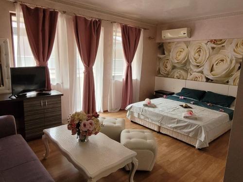 a bedroom with a bed with roses on the wall at Хотел “Райски кът” in Cheresha