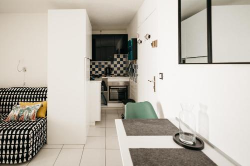 un petit salon avec un canapé et une cuisine dans l'établissement Cosy T1, à 10 minutes à pieds des plages, à Fréjus