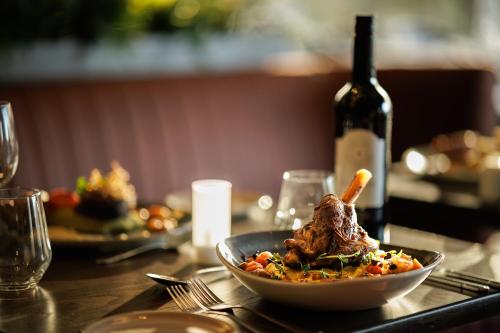 a table with a bowl of food and a bottle of wine at Hotel Woodstock Ennis in Ennis