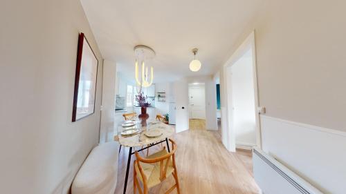une cuisine blanche avec une table et des chaises dans une pièce dans l'établissement Helsinki, appartement atypique, à Reims