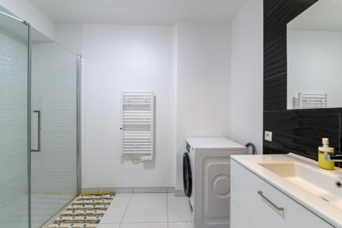 a bathroom with a sink and a washing machine at Le Duplex de Bougainville - Appt à 30min de Paris in Noisy-le-Grand