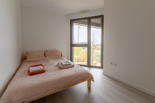 a bedroom with a bed and a large window at Le Duplex de Bougainville - Appt à 30min de Paris in Noisy-le-Grand