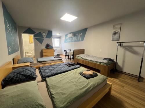 a room with three beds in a room at Maláta Homes in Budapest