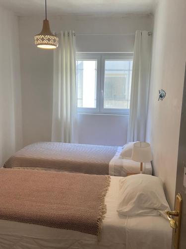 a bedroom with two beds and a window at Eskama guest house in Esposende