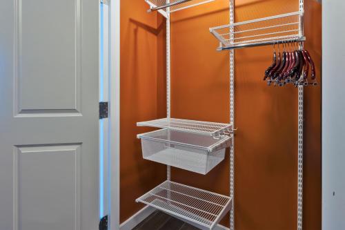 a closet with white shelves next to a door at TownePlace Suites by Marriott Grand Rapids Airport Southeast in Grand Rapids