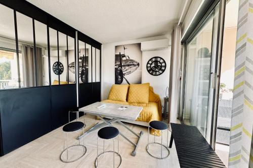 um quarto com uma mesa e dois bancos em Cosy family nest with balcony and shared pool em Mandelieu-la-Napoule