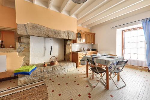 - une cuisine avec une table et une cheminée en pierre dans l'établissement Vacances apaisantes à Saint-Gildas-de-Rhuys, à Saint-Gildas-de-Rhuys