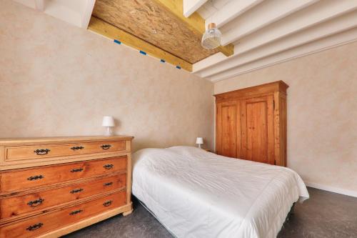 une chambre avec un lit et une commode en bois dans l'établissement Vacances apaisantes à Saint-Gildas-de-Rhuys, à Saint-Gildas-de-Rhuys