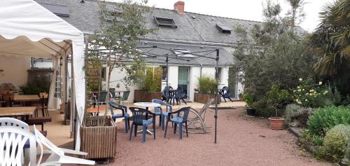 - une terrasse avec un bouquet de chaises et de tables dans l'établissement Cafe de la croix morzel, à Cordemais