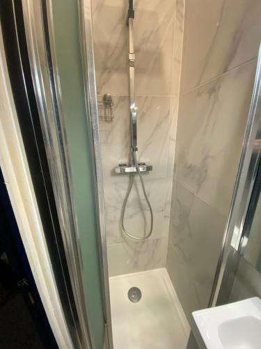 une douche avec une porte vitrée à côté d'un lavabo dans l'établissement Paris 6em, à Paris