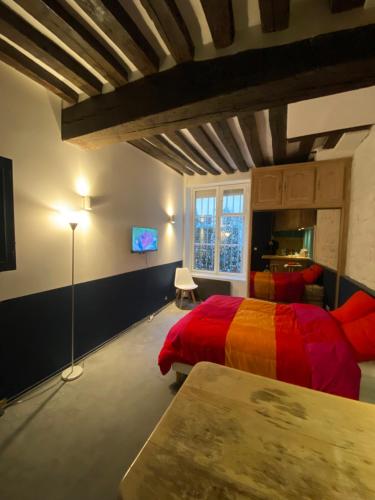 une chambre avec un lit rouge et une télévision dans l'établissement Paris 6em, à Paris