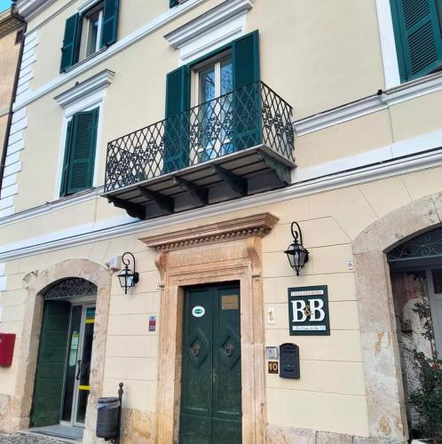 a building with a green door and a balcony at B&B - La Corte D'Ivi in Collepardo