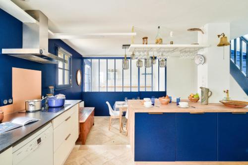 une cuisine avec des murs bleus et un comptoir en bois dans l'établissement À 30 m de la mer - Maison pour 7 à l' Île Tudy, à l'Île-Tudy