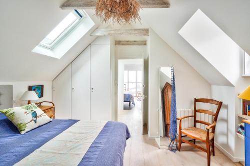 une chambre avec un lit et une chaise dans l'établissement À 30 m de la mer - Maison pour 7 à l' Île Tudy, à l'Île-Tudy