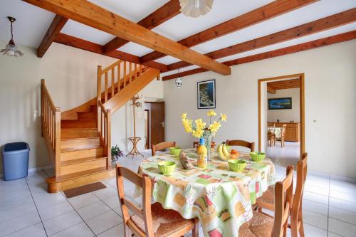 une salle à manger avec une table et un escalier dans l'établissement Grand jardin et calme au coeur des Côtes-d'Armor, à La Bouillie