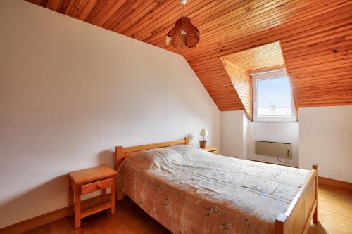 een slaapkamer met een bed en een houten plafond bij Sejour detente et decouverte des Cotes-d Armor in La Bouillie