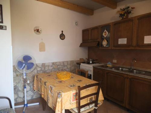 eine Küche mit einem Tisch mit einem Ventilator und einer Spüle in der Unterkunft Casetta vista mare 2 Climatizzata in Castellammare del Golfo