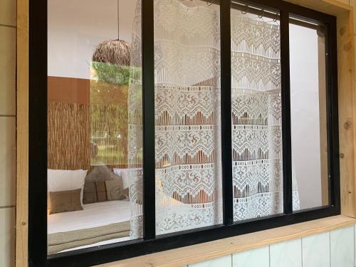 una ventana con cortinas y una cama en una habitación en Lou Tapata, en Estang