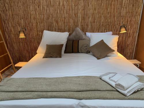 1 cama grande con sábanas y almohadas blancas en Lou Tapata, en Estang