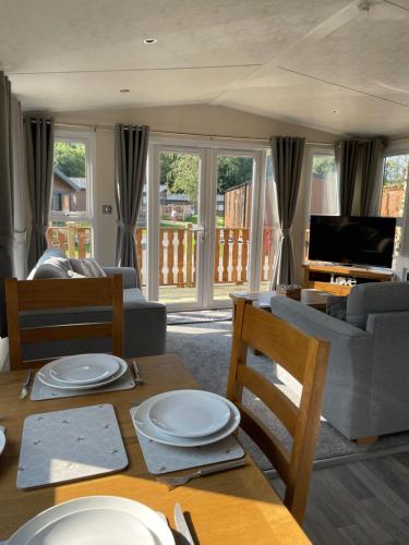 a living room with a table and a couch at 26 Sherwood, South Lakeland Leisure Village in Carnforth