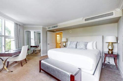 1 dormitorio con 1 cama blanca grande y escritorio en Marco Beach Ocean Resort 601, en Marco Island