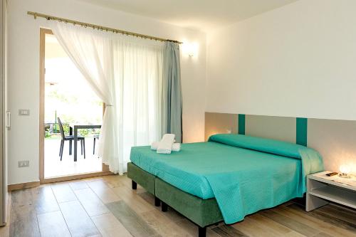 a bedroom with a bed and a large window at MOLAROTTO CAMERE CON ANGOLO COTTURA in San Teodoro
