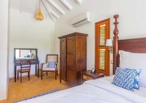 a bedroom with a bed and a desk and a chair at Villa Marie - Habitation Saint Charles in Petit-Bourg
