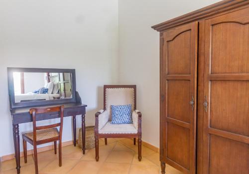 a room with a desk and a chair and a mirror at Villa Marie - Habitation Saint Charles in Petit-Bourg