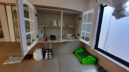 a kitchen with white cabinets and a sink at Alma de cedrela in Puerto Ayora