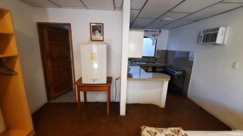 a kitchen with a refrigerator and a table in a room at Alma de cedrela in Puerto Ayora