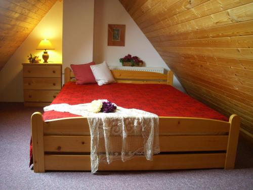 sypialnia z drewnianym łóżkiem i czerwonym kocem w obiekcie Apartment Herlikovice w Trutnovie