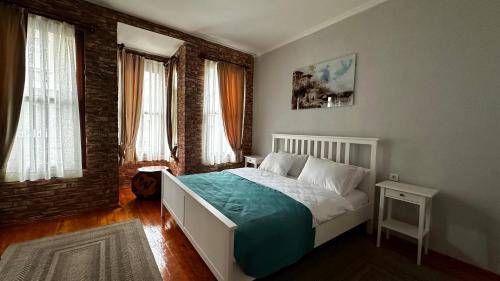 a bedroom with a bed and two windows at Lia Suit Beşiktaş in Istanbul