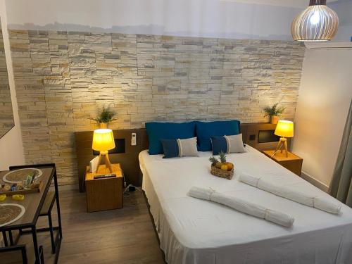 a bedroom with a large bed with blue pillows at The Ohana Studio in Saint-François